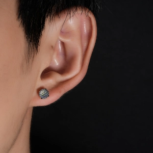 Detailed close-up of a four-claw firework cut stud earring worn on a model earlobe