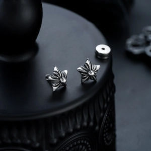 Macro shot of punk style stainless steel star earrings with vintage oxidized finish