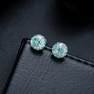 Macro shot of light blue gemstone stud earrings with a four-claw stainless steel setting