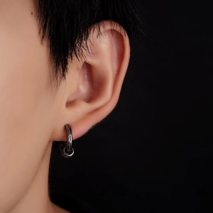 Macro detail of vintage silver hoop earring featuring intricate arabesque floral engravings