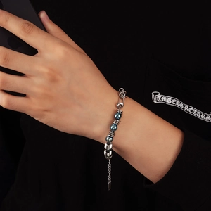 Détail du bracelet en perles d'acier industriel avec perles bleu foncé et anneaux en métal