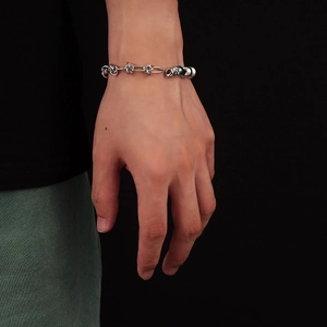 Détail d'un bracelet en acier inoxydable de style industriel avec des perles polies