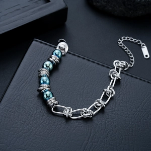 Détail d'un bracelet chaîne en acier poli avec perles métalliques bleues sur cuir