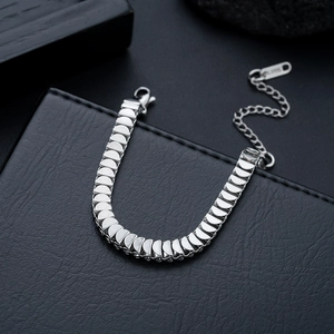 Detailed macro view of silver fish scale link bracelet with lobster clasp on black leather