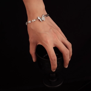Silver butterfly bracelet with crystal beads on wrist, elegant jewelry for women