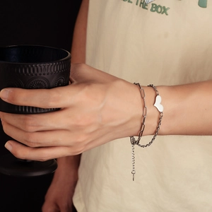 Double-layered stainless steel heart bracelet with paperclip chain on a model