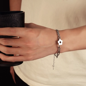 Polished silver chain bracelet featuring a geometric hollow flower charm on a curb link strap