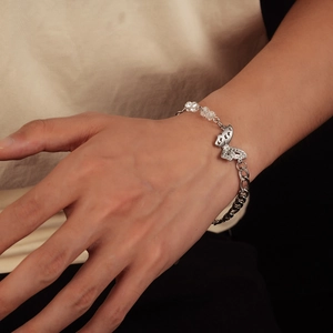 Silver butterfly charm bracelet with Cuban chain and transparent beads on wrist