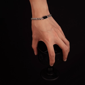Silver Cuban chain bracelet with black rectangular gemstone on model wrist
