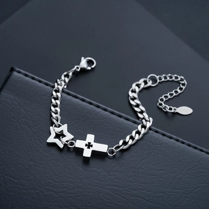 Detail of silver cross and star pendants on heavy industrial link chain bracelet