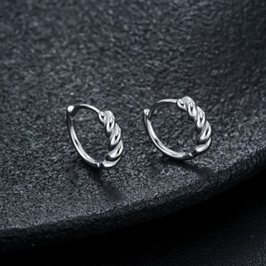 Macro shot of silver twisted hoop earrings with detailed metallic texture and hinge