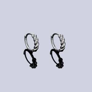 Silver-tone twisted rope hoop earrings with a mirror reflection on a sleek dark surface