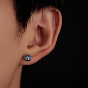 Detailed close-up of shell-shaped stud earring with dark blue enamel and silver trim
