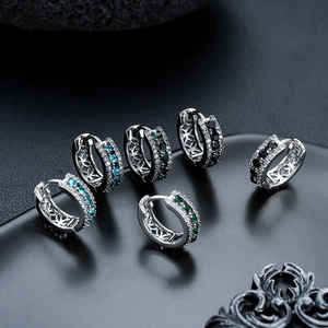 Trois paires de boucles d'oreilles huggie en zircon bleu, vert et noir avec motifs évidés
