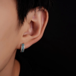 Vue macro de boucles d'oreilles créoles en argent serties de zircons bleus et blancs