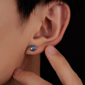Exquisite silver seashell stud earrings with blue enamel, displayed on a female model