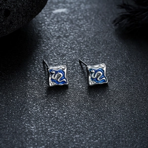 Gros plan de boucles d'oreilles carrées en métal argenté avec motif vague bleue