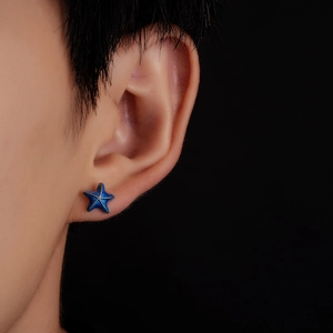 Detailed close-up of a blue starfish stud earring with silver accents on earlobe