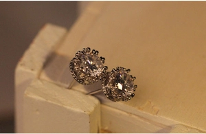 Dettaglio macro di orecchini a corona in argento con pietre di zirconia cubica tonda