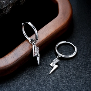 Macro shot of silver lightning bolt earrings with inset zircon stones on a dark base