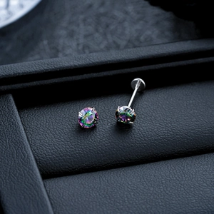 Macro shot of 4-prong titanium labret stud with iridescent crystal on black leather