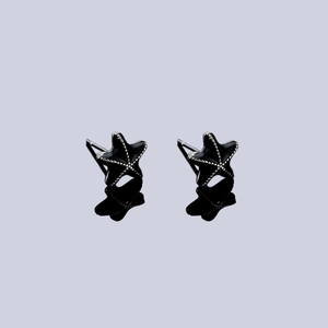 Macro detail of black starfish stud earrings with silver beaded edges and mirror reflection