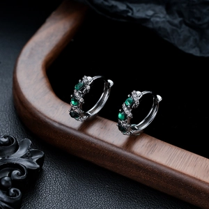 Detailed macro view of vintage emerald green zircon earrings set in S925 silver metal