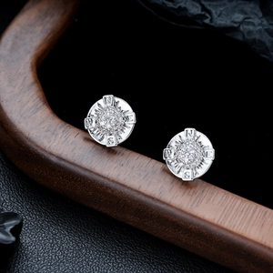 Macro shot of silver compass earrings with micro-paved zircons and NESW engravings