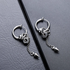 Macro detail of silver punk earrings featuring long chains and conical spikes on leather