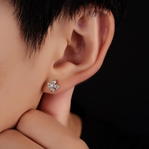 Boucles d'oreilles lotus en argent avec cristaux portées sur fond noir minimaliste