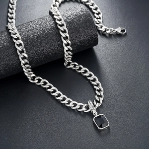 Detail of silver Cuban chain with black gemstone pendant and Lucky engraving