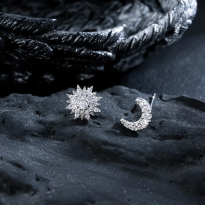 Sparkling sun and moon stud earrings with zircon inlay on dark volcanic rock