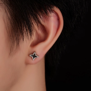 Macro view of four-pointed star stud earring with black enamel and white zircon inlay
