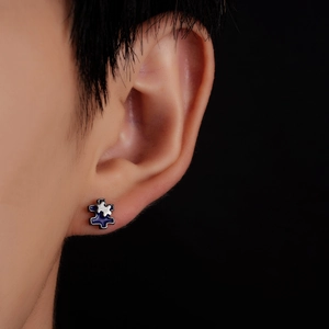 Detailed close-up of blue and silver interlocking puzzle piece stud earrings in macro view