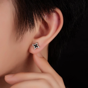 Star-shaped stud earring with black center stone and zircon pavé on model ear
