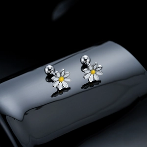 Macro shot of stainless steel daisy earrings with white petals and yellow centers