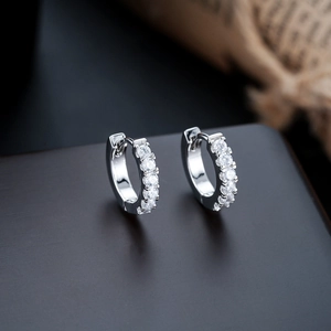 Close-up of sparkling silver hoop earrings with round cubic zirconia in channel setting