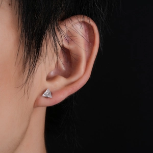 Close-up of minimalist triangle zircon stud earring with three-prong setting on ear