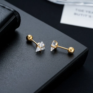 Detailed view of triangle zircon stud earrings with golden screw-back ball closures