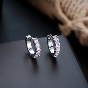 Close-up of S925 silver huggie earrings with pavé set pink cubic zirconia stones