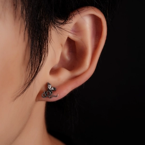 Détail d'une boucle d'oreille serpent en acier titane vintage avec pierres de zircone