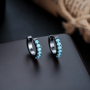 Detail of gunmetal huggie earrings with six inlaid turquoise beads in 4-prong setting
