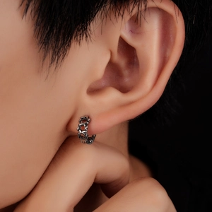 Boucles d'oreilles minimalistes en acier titane ajouré montrées sur un mannequin homme