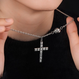 Gothic cross necklace with skull detail and Imagine Peace engraving on black sweater