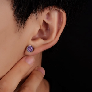 Detail view of round purple glitter titanium steel stud earring on a male model