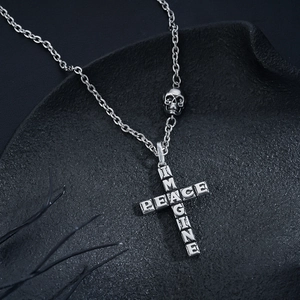 Silver cross necklace with 'IMAGINE' and 'PEACE' letters and skull bead on dark rock