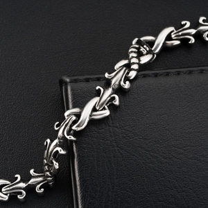 Detailed macro view of vintage titanium steel chain with gothic fleur-de-lis engraving