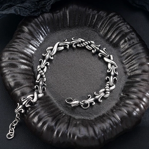 Detail of gothic fleur-de-lis titanium steel bracelet with vintage finish on dark plate