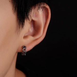 Vue macro de la boucle d'oreille en titane avec des motifs géométriques tissés