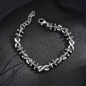 Retro titanium steel bracelet with fleur-de-lis links and lobster clasp on dark background
